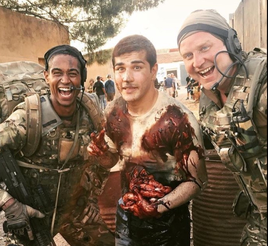 actors dressed as soldiers, one bloodied