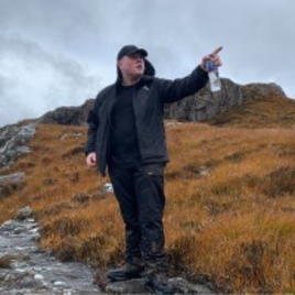 young man wearing black on a rural path.