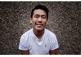 young man of SE Asian heritage smiling and wearing a white T-Shirt