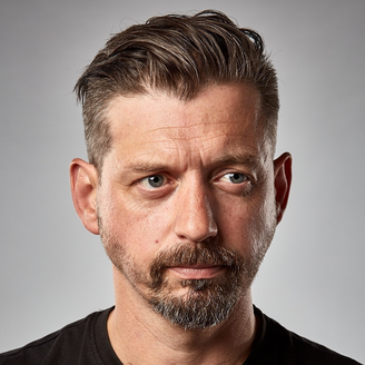 colour photo of young man's head - caucasian, mid brown short hair, beard and moustache.