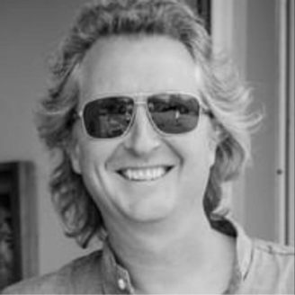 caucasian male with mid length wavy hair wearing sunglasses